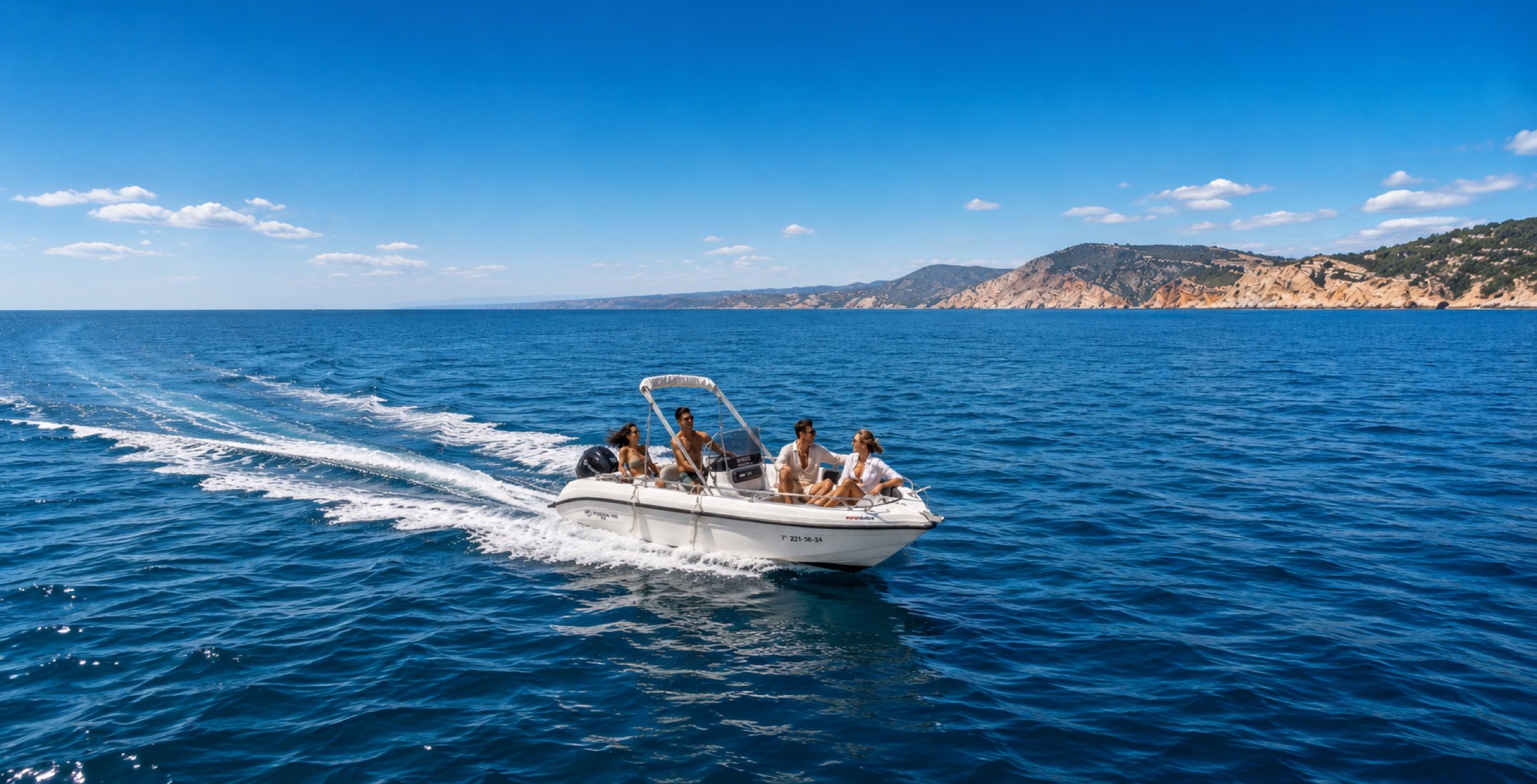 Wide view of the small boat crossing calm open water near the coast