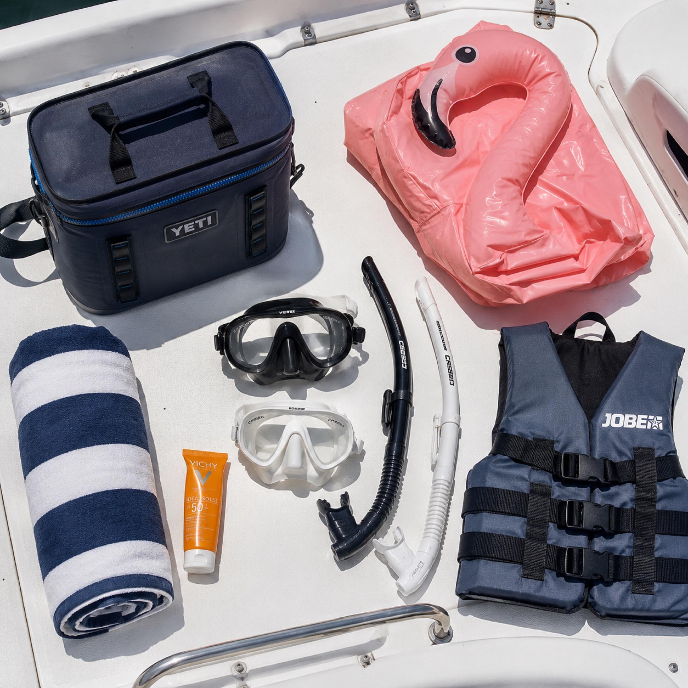 Everything included laid out on the deck: masks, snorkels, life jacket, cool box, towel, sun cream and the inflatable flamingo